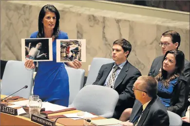  ?? Picture: REUTERS ?? GRIM DETAILS: US Ambassador to the United Nations, Nikki Haley, holds up photograph­s at the UN in New York of 86 victims, mostly children who died in what is believed to be a chemical attack in northern Syria on Tuesday