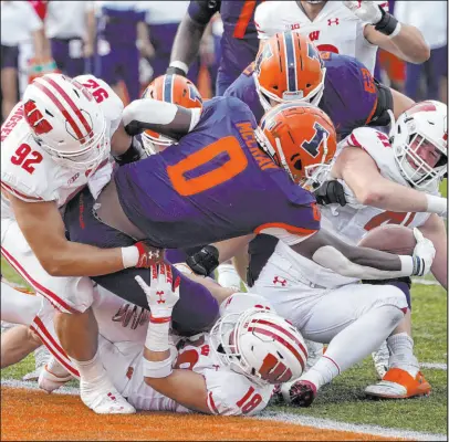  ?? Charles Rex Arbogast The Associated Press ?? Illinois running back Joshua Mccray is stuffed at his team’s 1-yard line by Wisconsin defenders Matt Henningsen (92) and Collin Wilder (18) during the Badgers’ 24-0 road win on Oct. 9.