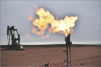  ?? MATTHEW BROWN/AP ?? A FLARE BURNS NATURAL GAS at an oil well on Aug. 26, in Watford City, N.D.