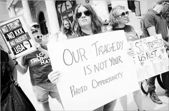  ?? JOHN MINCHILLO THE ASSOCIATED PRESS ?? Protesters against a scheduled visit from U.S. President Donald Trump holds signs outside city hall Tuesday in Dayton, Ohio. Trump was planning to visit both Dayton and El Paso, Texas, on Wednesday.