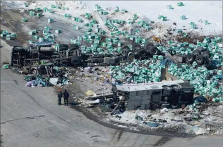  ?? JONATHAN HAYWARD — THE CANADIAN PRESS VIA AP ?? Emergency personnel work at the scene of a fatal crash outside of Tisdale, Saskatchew­an, Canada, Saturday, April, 7. A bus en route to Nipawin, foreground, carrying the Humboldt Broncos junior hockey team crashed into a truck, killing 15 and sending...