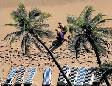  ?? Photo: REUTERS ?? Two women walk along North Fort Lauderdale beach in Fort Lauderdale, Florida. The miles of sandy beaches are popular with families and students on their ‘spring break’.