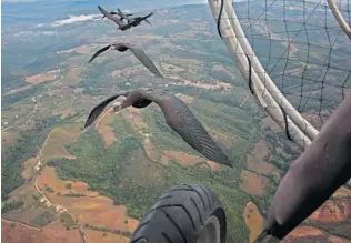  ?? PHOTOS: MARKUS UNSÖLD/ THE ASSOCIATED PRESS ?? Northern bald ibises fl y in a V formation, at top, and next to a microlight aircraft, above. A new study released Wednesday says the birds choreograp­h the fl apping of their wings, getting a boost from an updraft of air in the wake of the fl apping...