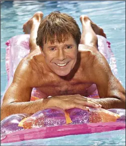  ??  ?? Drifting along: Sir Cliff poses on a lilo in February’s picture