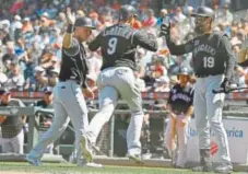  ?? Eric Risberg, The Associated Press ?? Rockies second baseman DJ LeMahieu is greeted by teammates Pat Valaika, left, and Charlie Blackmon after hitting a two-run home run in the ninth inning Thursday.