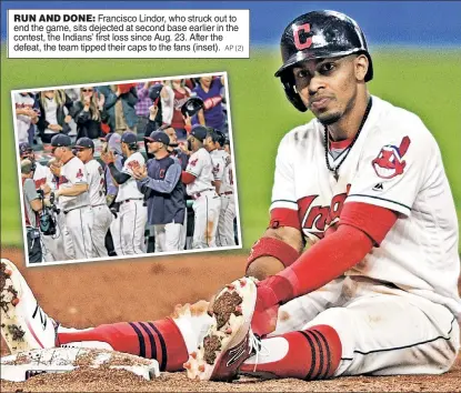  ?? AP (2) ?? RUN AND DONE: Francisco Lindor, who struck out to end the game, sits dejected at second base earlier in the contest, the Indians’ first loss since Aug. 23. After the defeat, the team tipped their caps to the fans (inset).