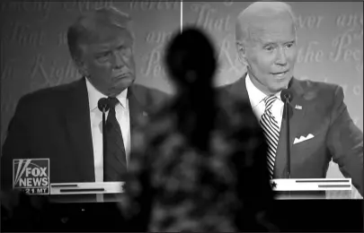  ?? MARK MAKELA / THE NEW YORK TIMES ?? A woman watches a debate between then-president Donald Trump and Joe Briden on Sept. 29, 2020, at a watch party in Lititz, Pa.