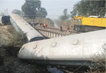  ?? AFP ?? Officials and bystanders gather beside the wreckage of train carriages at Rura, 30km west of Kanpur, on Wednesday. —