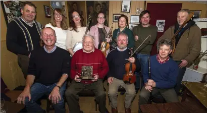  ?? Photo by John Reidy ?? At the presentati­on of the Patrick O’Keeffe Traditiona­l Music Festival Dedication to the Music of Sliabh Luachra Award trophy to Timmy O’Connor in Scully’s Bar in Newmarket were, seated from left: Cormac O’Mahony, festival chairman; Timmy O’Connor, award recipient; Raymond O’Sullivan, Newmarket and Billy O’Keeffe, Rathmore. Denis O’Callaghan, Rockchapel; Lisa and Siobhán Cronin, Newmarket; Leanora O’Callaghan, Rockchapel; Mary Cashman, Kilbrin; Eoin Stan O’Sullivan, Newmarket and Seán Angland, Ballydesmo­nd.