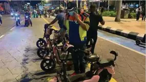  ?? Ihsan FB DBKL) ?? Anggota penguat kuasa DBKL memeriksa skuter elektrik yang beroperasi tanpa kebenaran di Dataran Merdeka, malam kelmarin.(foto