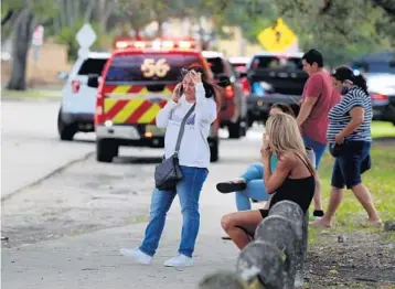 ?? CARLINE JEAN/SOUTH FLORIDA SUN SENTINEL ?? Parents and family members wait to pick up kids at South Plantation High School after it was placed on lockdown Friday.