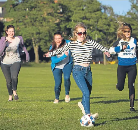  ??  ?? Dundee University students (from left) Emily Kerr, Elizabeth Heywood, Rachael Logan and Kathryn Brice enjoying the fine weather and a game of football at Dundee’s Magdalen Green during a break from studying.