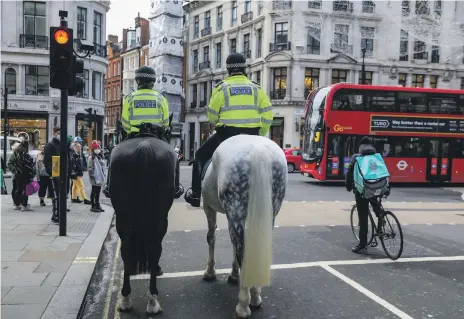  ?? Reuters ?? Mounted police and a Deliveroo rider on London’s Regent Street. Deliveroo’s IPO will use the dual-class share structure