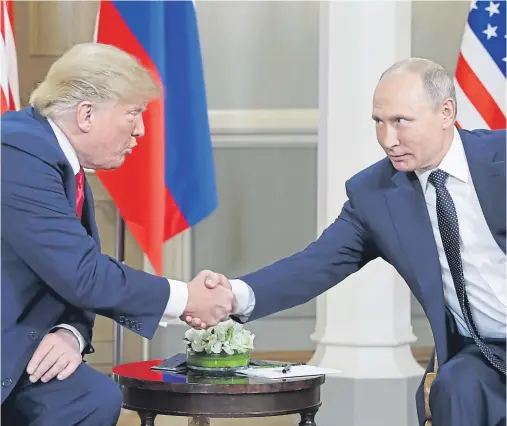  ??  ?? ‘SUCCESSFUL AND USEFUL’: Donald Trump and Vladimir Putin shake hands in front of the media following their summit in Helsinki