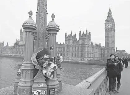 ?? NIKLAS HALLE'N, AFP/ GETTY IMAGES ?? Flowers placed on Westminste­r Bridge on Friday memorializ­e victims of a terror attack that left four dead Wednesday at the iconic London site and in front of the adjacent Houses of Parliament.