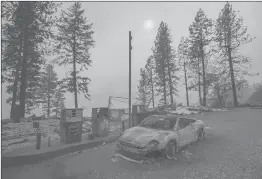  ?? NOAH BERGER | ASSOCIATED PRESS ?? AS THE Camp Fire burns nearby, a scorched car rests by gas pumps near Pulga, Calif., on Sunday. With 29 deaths, the Camp Fire has matched the deadliest wildfire in California history.