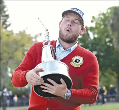  ?? AP Photo/Phelan M. Ebenhack ?? Tyrrell Hatton, of England, reacts to the weight of the championsh­ip trophy after posing for photos with it after winning the Arnold Palmer Invitation­al Sunday in Orlando, Fla.
