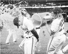  ?? FRED THORNHILL THE CANADIAN PRESS ?? Cavan Biggio gets a Gatorade shower from Vladimir Guerrero Jr. in a post-game interview after the Jays defeated San Diego, 10-1.