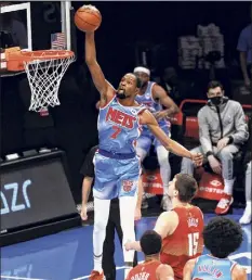  ?? Sarah Stier / Getty Images ?? Kevin Durant (7) of the Nets dunks as Nikola Jokic (15) looks on during the first half on Tuesday in Brooklyn.