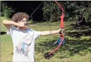  ?? / Doug Walker ?? Nicholas Fisher draws back his bow during the first RomeFloyd ECO Center archery lessons Tuesday. Fisher is one of 20 home-schooled students who got a three-hour archery program at the ECO Center Tuesday.