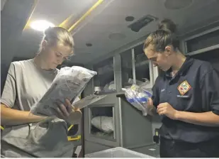  ?? BY SARA SCHONHARDT ?? Angelica Vittitow (left), captain of Chester Gap's emergency medical service, walks EMT trainee Cora Snyder through a regular supply check of the ambulance.