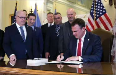  ?? SARAH PHIPPS — THE OKLAHOMAN VIA AP ?? Oklahoma Gov. Kevin Stitt signs an executive order in the Blue Room at the state Capitol in Oklahoma City, Dec. 13, 2023. Stitt signed an executive order barring state agencies and universiti­es from spending money on diversity initiative­s.