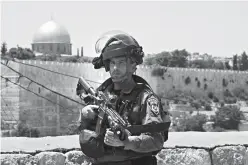  ?? Associated Press ?? n An Israeli border police officer stands guard Friday outside in Jerusalem’s Old City. Israel closed the site—known to Muslims as the Noble Sanctuary and to Jews as the Temple Mount—on Friday after three Arab citizens of Israel opened fire from the...