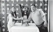  ?? [PHOTO BY STEVEN CHRISTY, ENERGY FC] ?? La Oaxaquena Bakery owner Ramiro Padilla, right, and Katie Hernandez have their picture taken with Pachuca’s 2017 CONCACAF Champions League trophy Monday. Pachuca made appearance­s at numerous Oklahoma City businesses Monday ahead of Tuesday’s friendly...