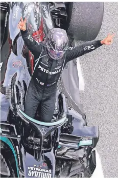  ?? FOTO:LARS BARON/AP ?? Mercedes-PilotLewis Hamilton jubelt über seinen Grand-Prix-Sieg in Spanien als er aus seinem Formel-1-Rennwagen aussteigt.