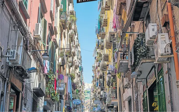  ?? Pictures: iStock ?? BALCONY SCENE Apartment fronts seem to lean into one another above the colourful streets of Naples, Italy.