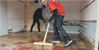  ??  ?? Students putting their backs into cleaning.