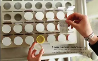  ??  ?? A nurse matches patients’ names to their daily dosage of medicine at a mental hospital in Liaoning province