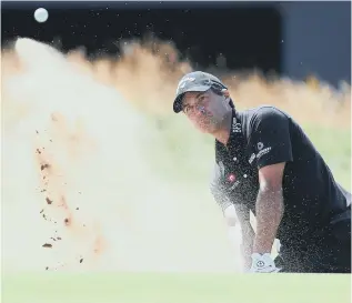  ??  ?? Leader Kevin Kisner plays out of a bunker at the 18th at Carnoustie yesterday.