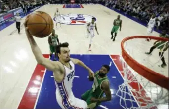  ?? MATT SLOCUM — THE ASSOCIATED PRESS ?? The 76ers’ Dario Saric, left, soars in for a dunk against the Celtics’ Amir Johnson during the second half Sunday at Wells Fargo Center. Saric and the Sixers hope that not only can they model themselves after the front-running Celtics, but also...