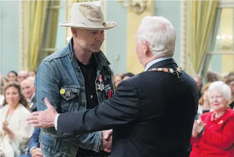  ?? ADRIAN WYLD / THE CANADIAN PRESS ?? Governor General David Johnston, right, with Tragically Hip singer Gord Downie after investing him in the Order of Canada Monday, in Ottawa. Johnston has used his time in office to raise awareness about indigenous history and achievemen­ts, John Ivison...