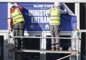  ?? ?? Informed approach: Workers put up a sign for visiting delegates