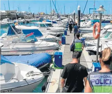  ?? CNP ?? Agentes de la Policía llevando a uno de los detenidos a un registro en un puerto deportivo.