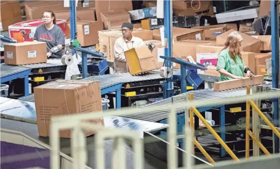  ?? MAX GERSH/THE COMMERCIAL APPEAL ?? Employees sort packages Dec. 4, 2019, at the Fedex Ground Olive Branch hub.