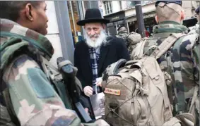  ?? THE ASSOCIATED PRESS ?? Soldiers patrol a street in Paris on Jan. 14, following the Paris attacks. The French government deployed 10,000 troops to protect sensitive sites, including Jewish schools and synagogues, mosques and travel hubs.