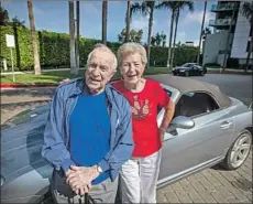  ??  ?? SOLOMON with her 99-year-old boyfriend, Eddie Huyffer, in front of her Crossfire convertibl­e. They first met 25 years ago while bowling.