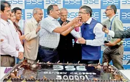  ??  ?? People celebrate with a 30 kilogram cake at the Bombay Stock Exchange as the Sensex hits 30,000 mark in Mumbai on Wednesday