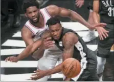  ?? MARY ALTAFFER — THE ASSOCIATED PRESS ?? Philadelph­ia 76ers center Joel Embiid, left, passes the ball around Brooklyn Nets guard Treveon Graham during the second half of Game 4 of a first-round NBA basketball playoff series, Saturday.