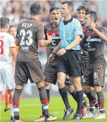  ?? FOTO: IMAGO ?? Diskussion mit Schiedsric­htern gibt es bei fast jedem Fußballspi­el – im Profiberei­ch wie hier mit Benjamin Cortus beim Spiel des FC St. Pauli gegen den 1. FC Köln sowie im Amateurber­eich. Die Folgen in den unteren Ligen sind gravierend.