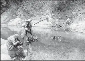  ??  ?? A Naked and Afraid production crew films Charlie Frattini and Dani Beau hiding from bugs in a river in Colombia during Season 4.