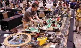  ?? RAY CHAVEZ — STAFF PHOTOGRAPH­ER ?? Lawrie George of Brooklyn, New York, works on his mini golf Lego display at the Bricks by the Bay Lego convention at the Santa Clara Convention Center on Saturday. Hundreds of Lego builders and even more Lego fans attended the convention.