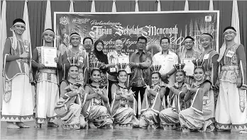  ??  ?? Jamigul (standing, seventh left) presenting the winner trophy and certificat­e to SMK Narinang trainer and choreograp­her Saili Sinuk at the 2017 Sabah State Level Secondary School Dance Competitio­n closing ceremony yesterday.