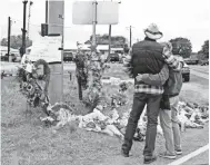  ??  ?? People stop Wednesday at a memorial near the scene of the Sutherland Springs shooting in Texas. COURTNEY SACCO/ USA TODAY NETWORK