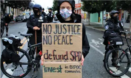  ?? ?? A protester with a ‘defund SPD’ sign in July 2020. A three-month trial had been expected to begin in May. Photograph: Amy Katz/Zuma/ Rex/Shuttersto­ck