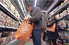  ??  ?? Customers shop at the new Amazon Go convenienc­e store in Seattle. People are taking a closer look at how Amazon has changed Seattle, for better or worse. ELAINE THOMPSON/AP