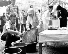  ??  ?? Tunku Azizah showing that bauxite can also be used as a dye and she managed to turn the simple T-shirt into an attractive orange and indigo-coloured shirt during the Natural Dye Creative Workshop yesterday. - Bernama photo